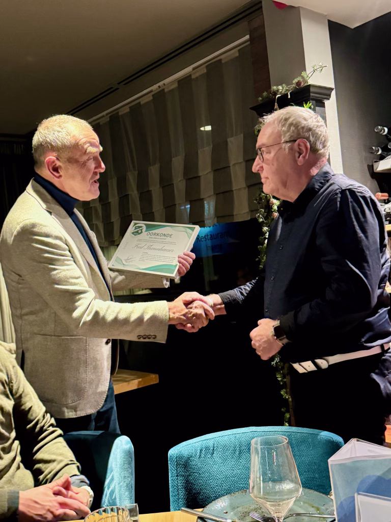 Voorzitter Guido Ronnes reikt Fred de oorkonde uit.